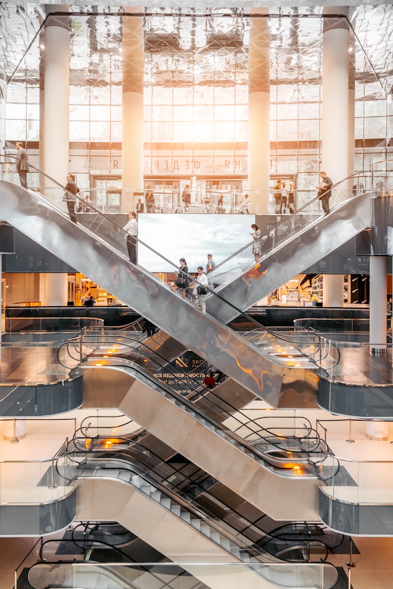 Modern multi-level shopping centre with escalators and shoppers